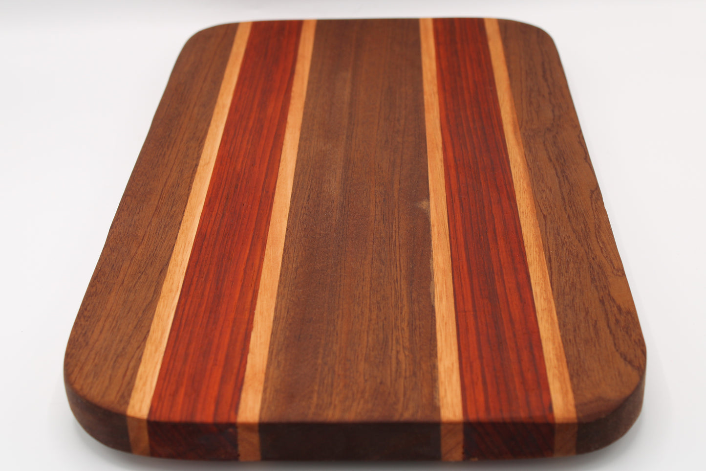 Wooden cutting board with multicolored stripes on a white background