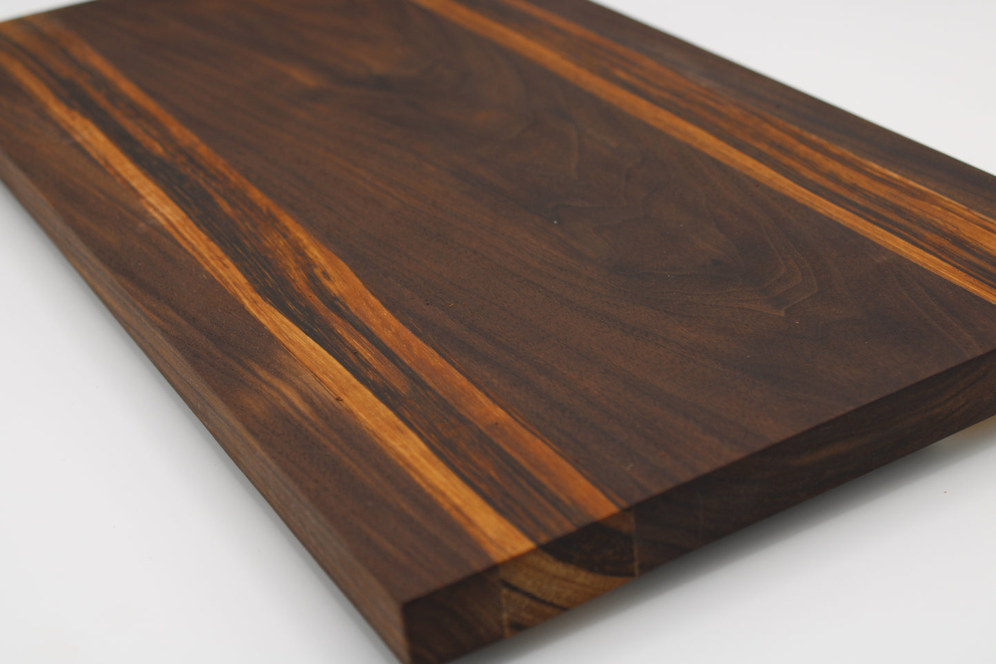 Wooden cutting board with a dark brown and orange grain pattern on a white background