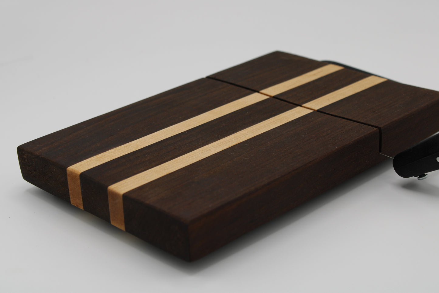 Wooden cheese board with a black slicer on a white background