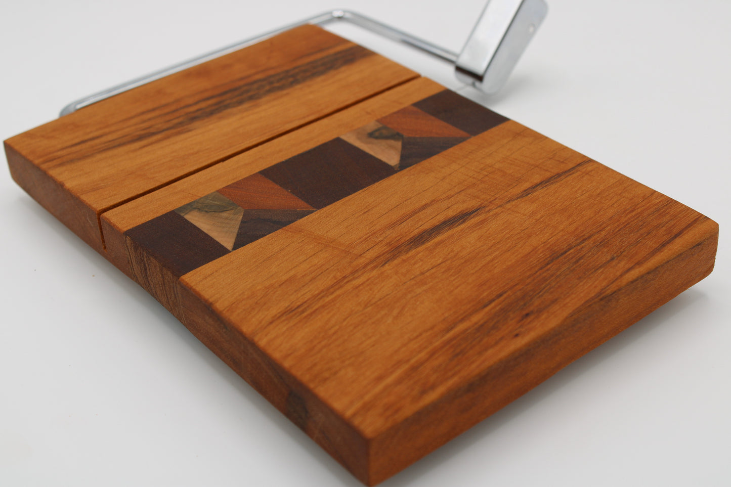 Wooden cheese board with slicer on a white background