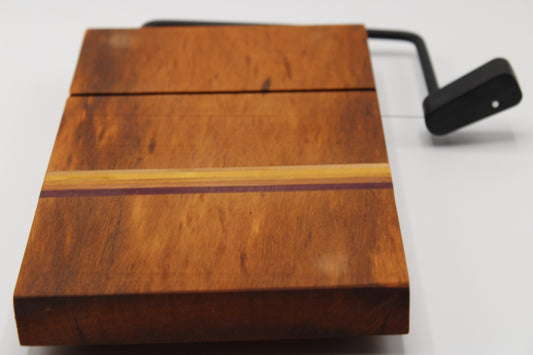 Wooden cheese cutting board with slicer on a light gray background