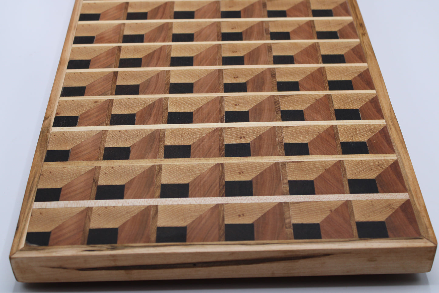 Wooden cutting board with a 3-D geometric pattern on a white background