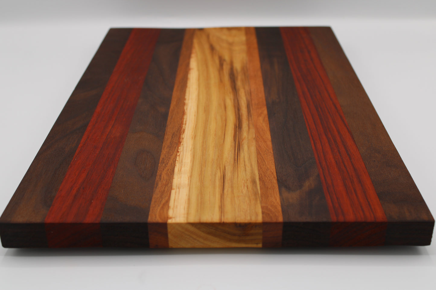 Wooden cutting board with multicolored stripes on a white background