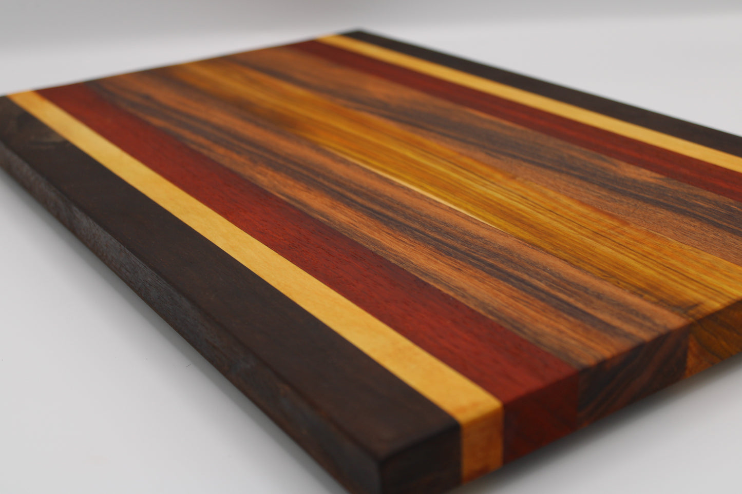Wooden cutting board with multicolored stripes on a white background