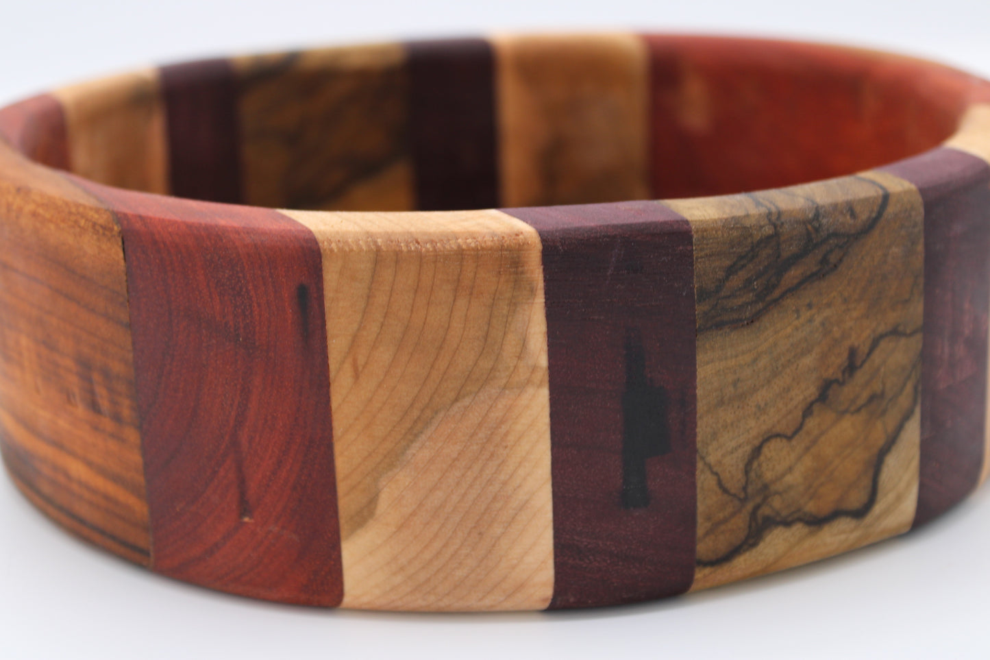Wooden bracelet with a striped pattern on a white background
