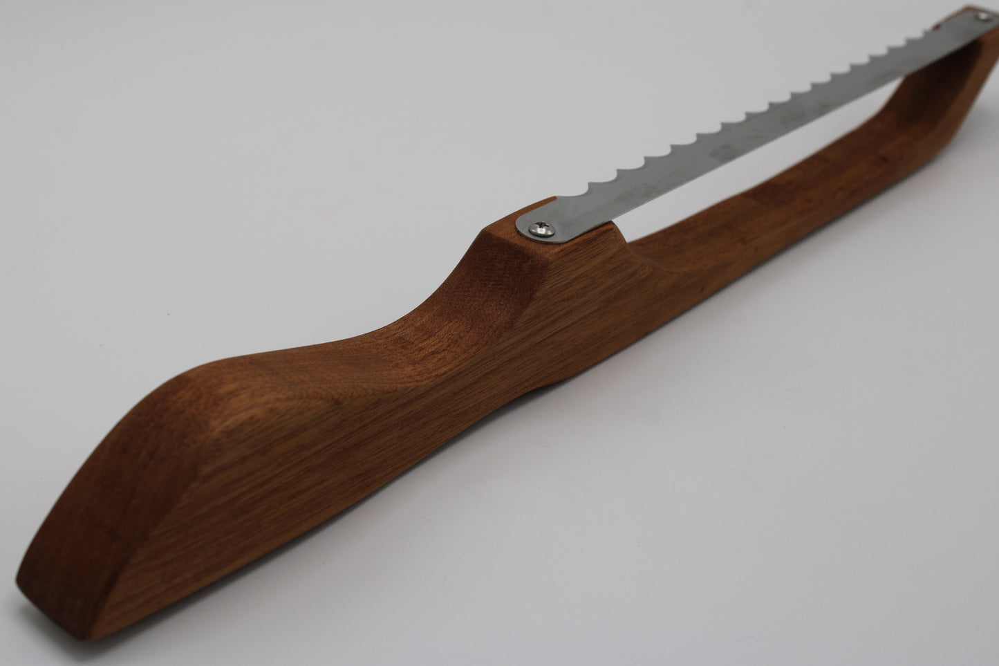 A hand saw with a curved brown wooden handle and a silver metal blade, photographed on a plain light gray background.