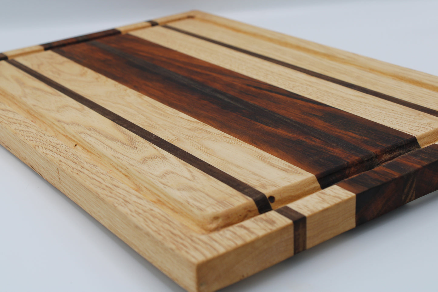 Wooden cutting board with stripe design on white background