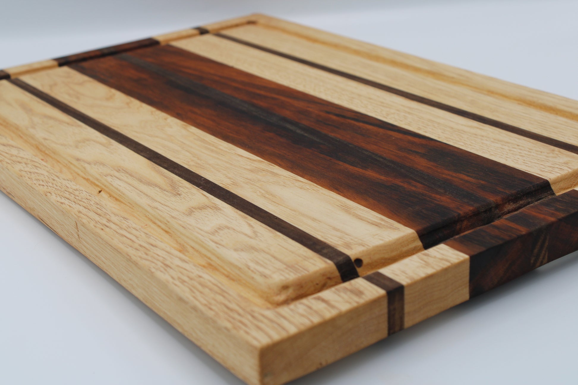 Wooden cutting board with stripe design on white background