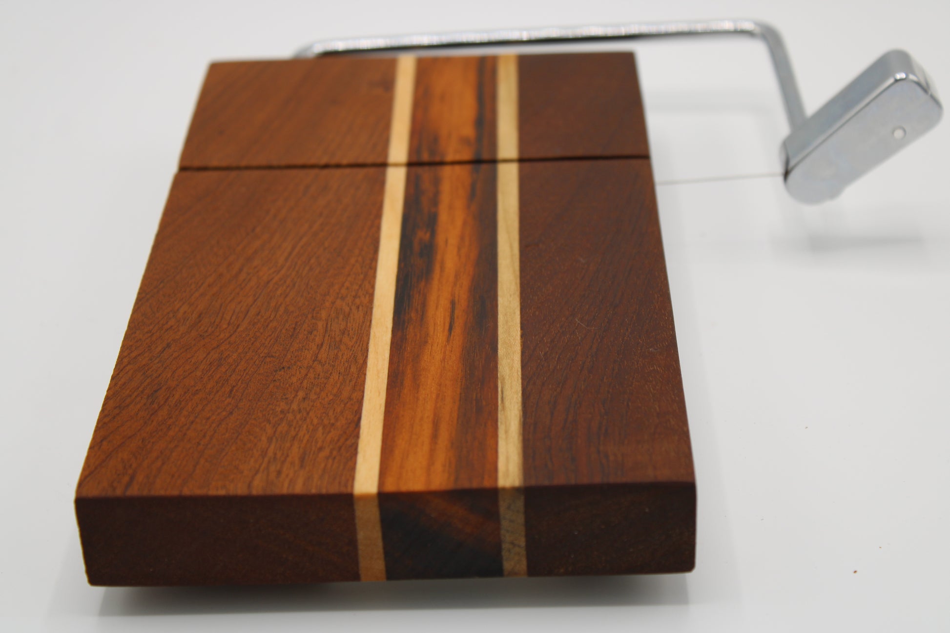 Wooden cheese board with slicer on a white background