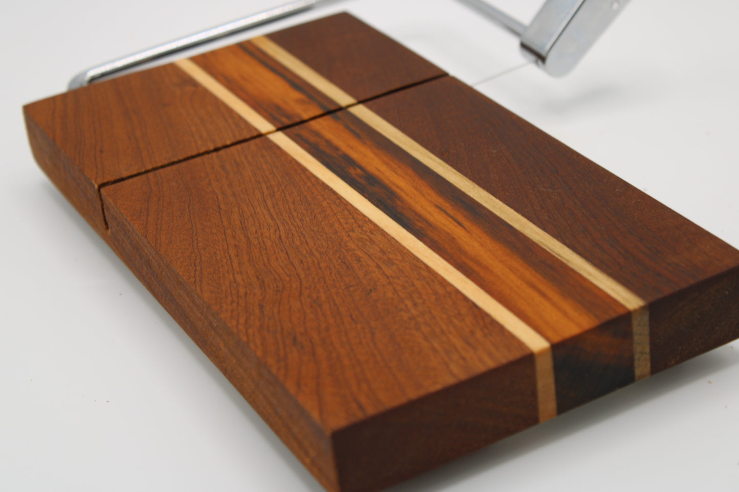 Wooden cheese board with slicer on a white background