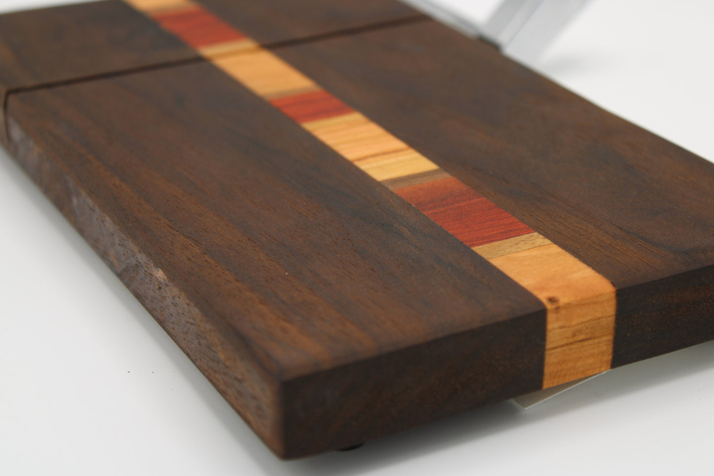 Wooden cutting board with a multicolored stripe on a white background