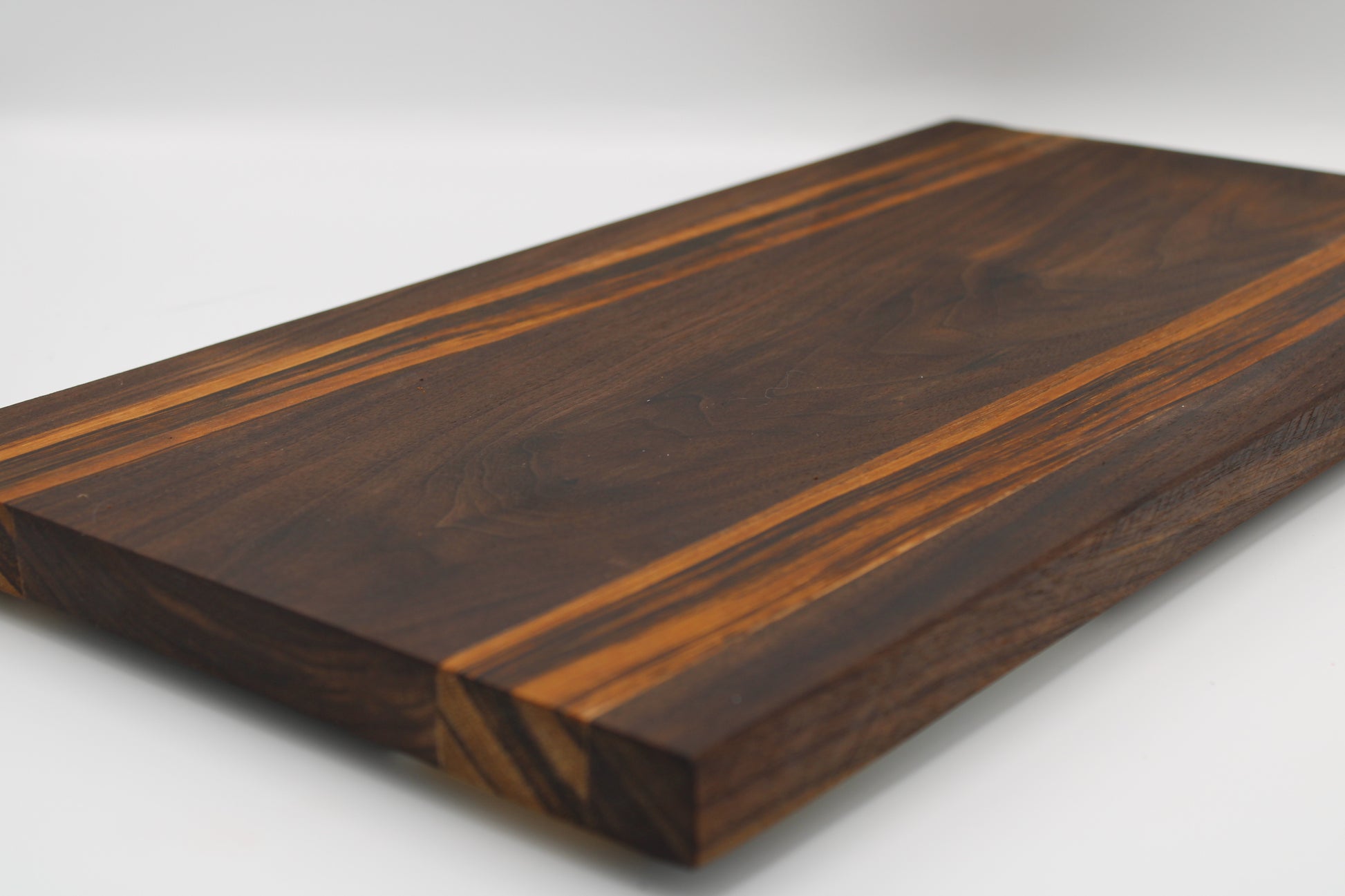 Wooden cutting board with a dark brown finish on a white background
