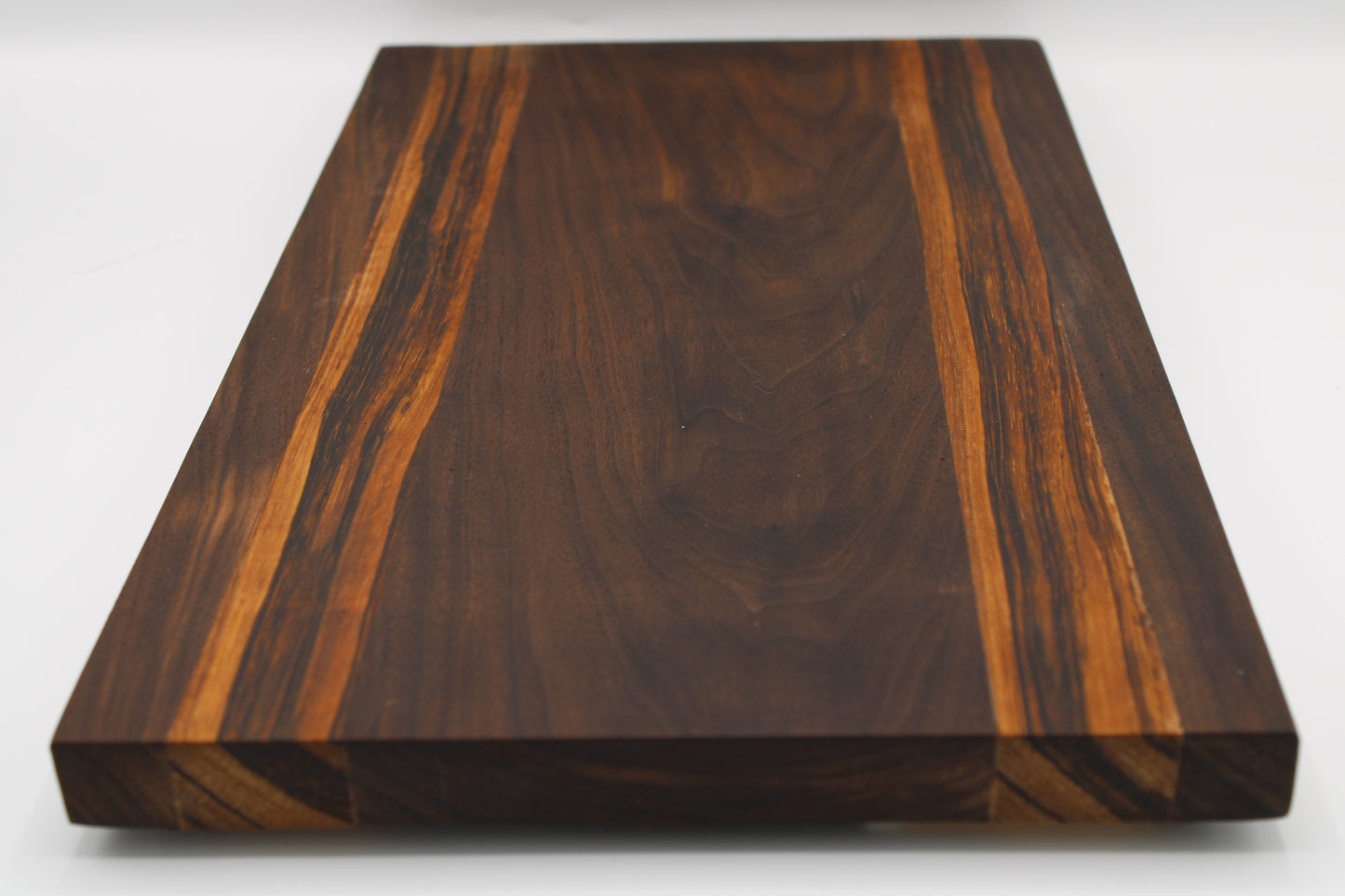 Wooden cutting board with a dark brown and orange grain pattern on a white background