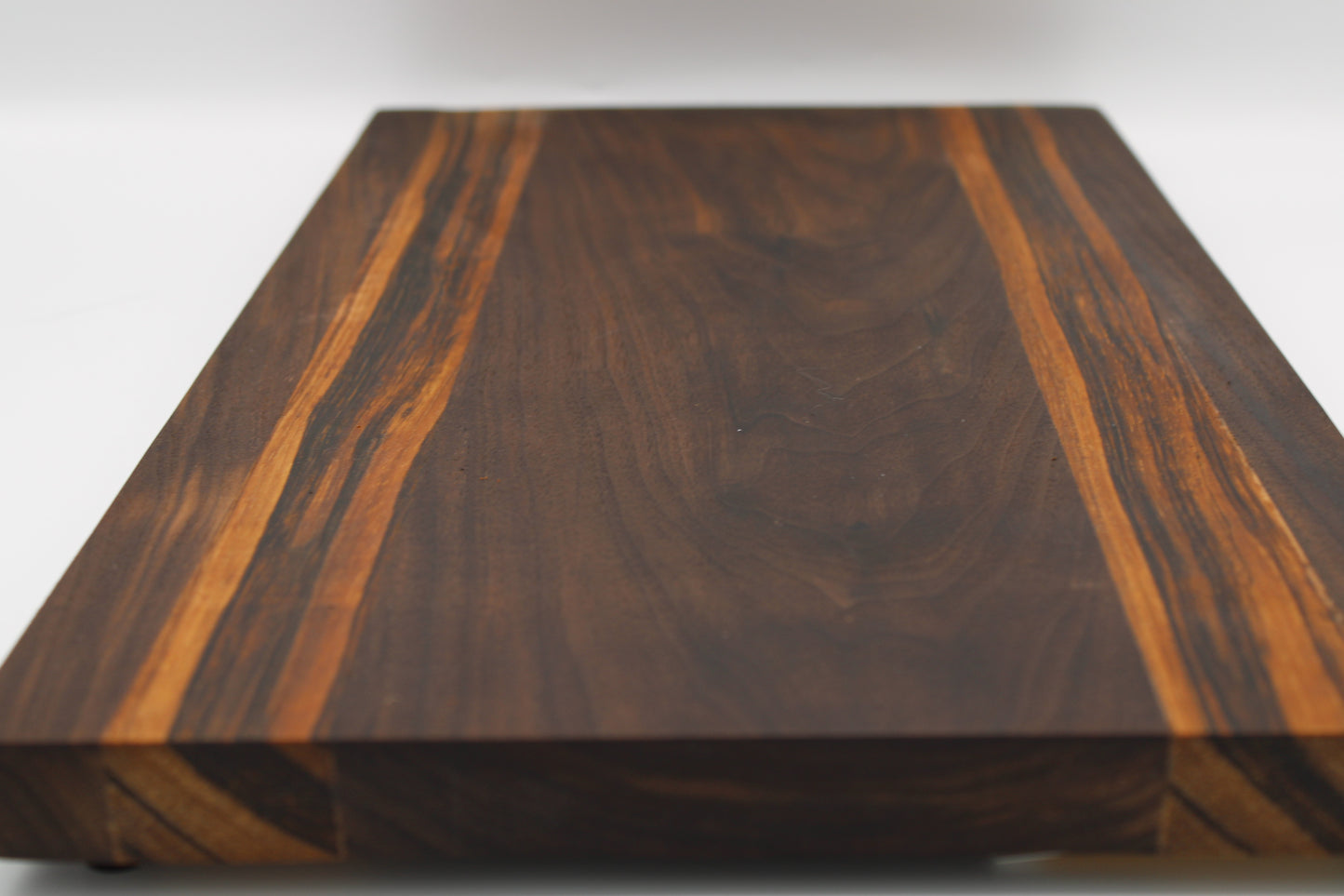 Wooden cutting board with a dark brown and orange grain pattern on a white background