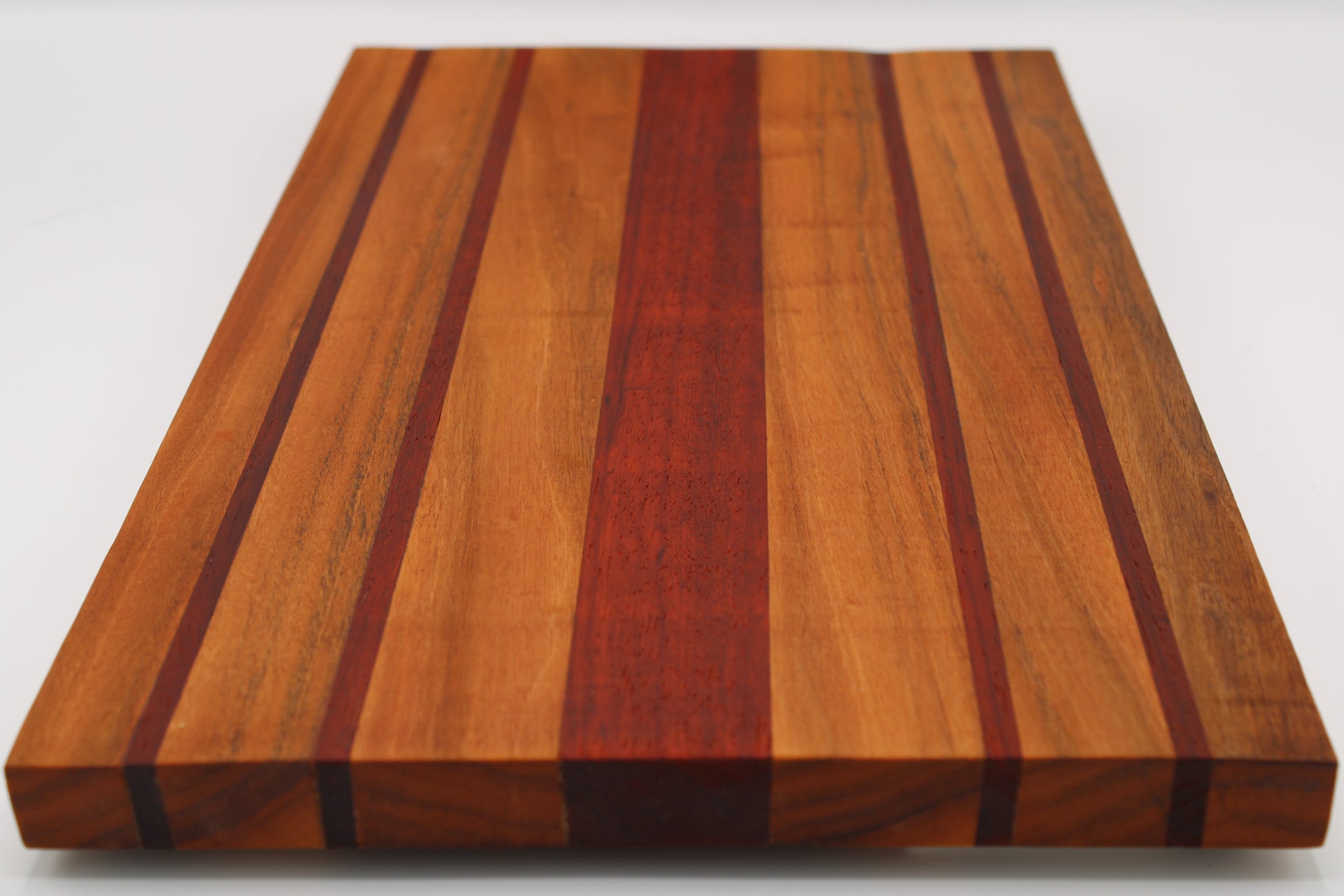 Wooden cutting board with striped pattern on a white background