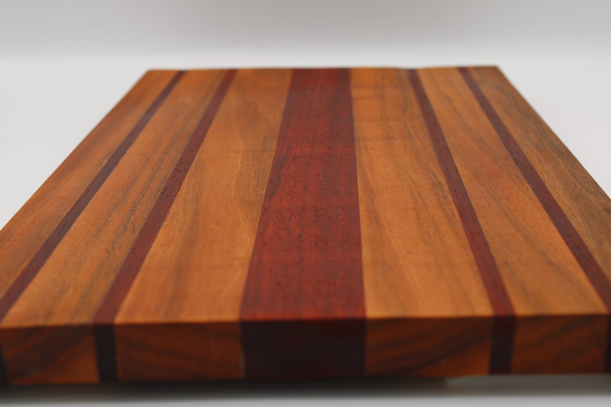 Wooden cutting board with striped pattern on a white background