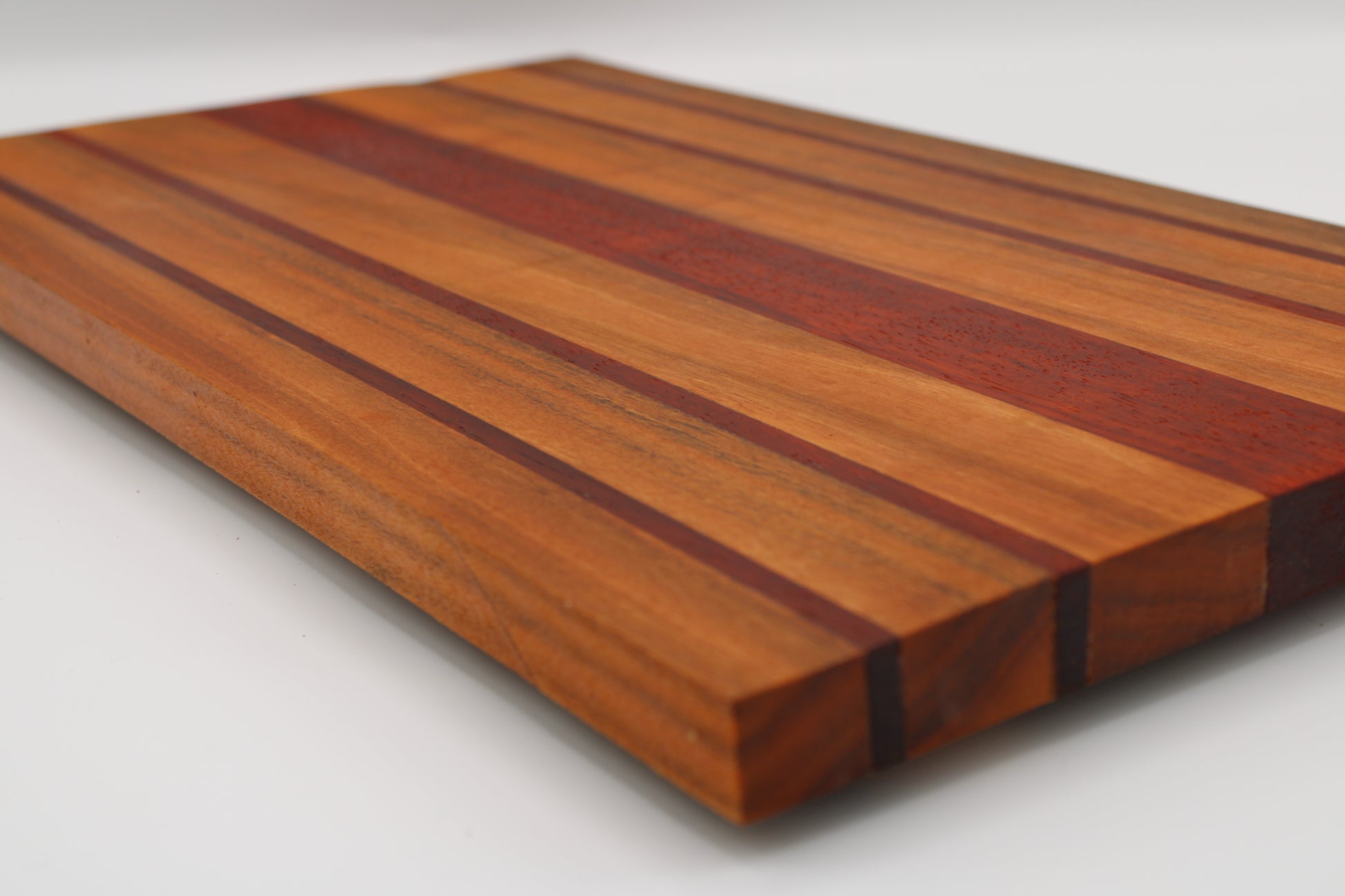 Wooden cutting board with striped pattern on a white background