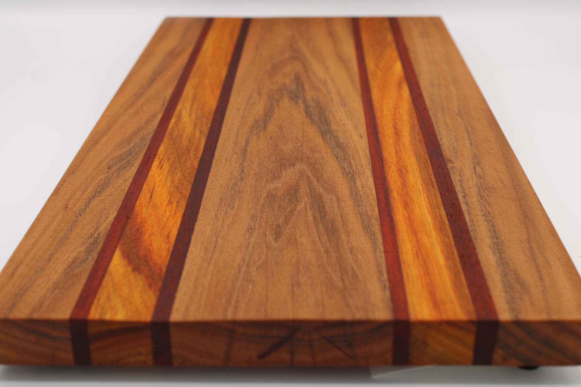 Wooden cutting board with a striped pattern on a white background