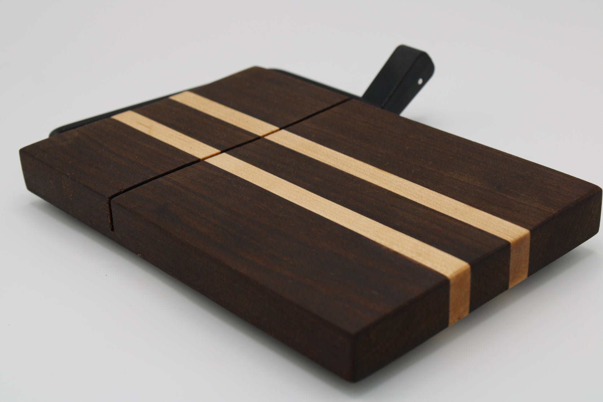 Wooden cheese board with a black slicer on a white background