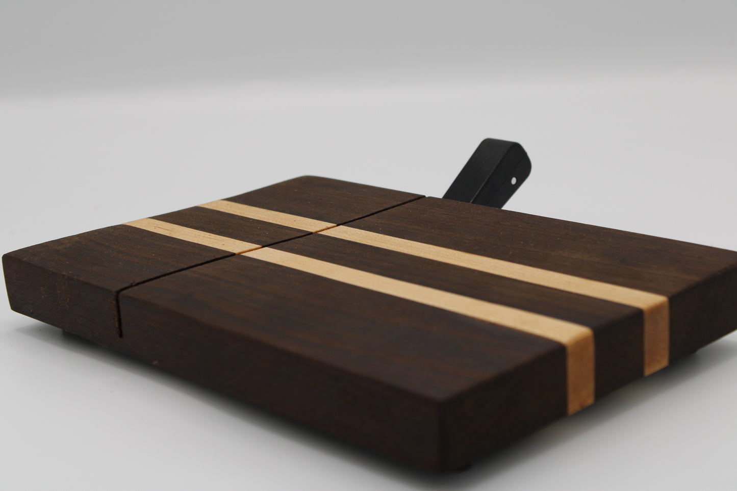Wooden cheese board with a black slicer on a white background