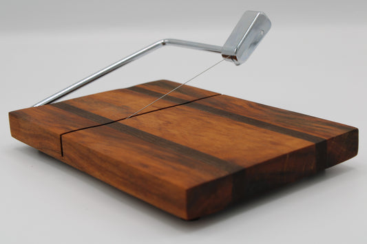 Wooden cheese board with a silver slicer on a white background