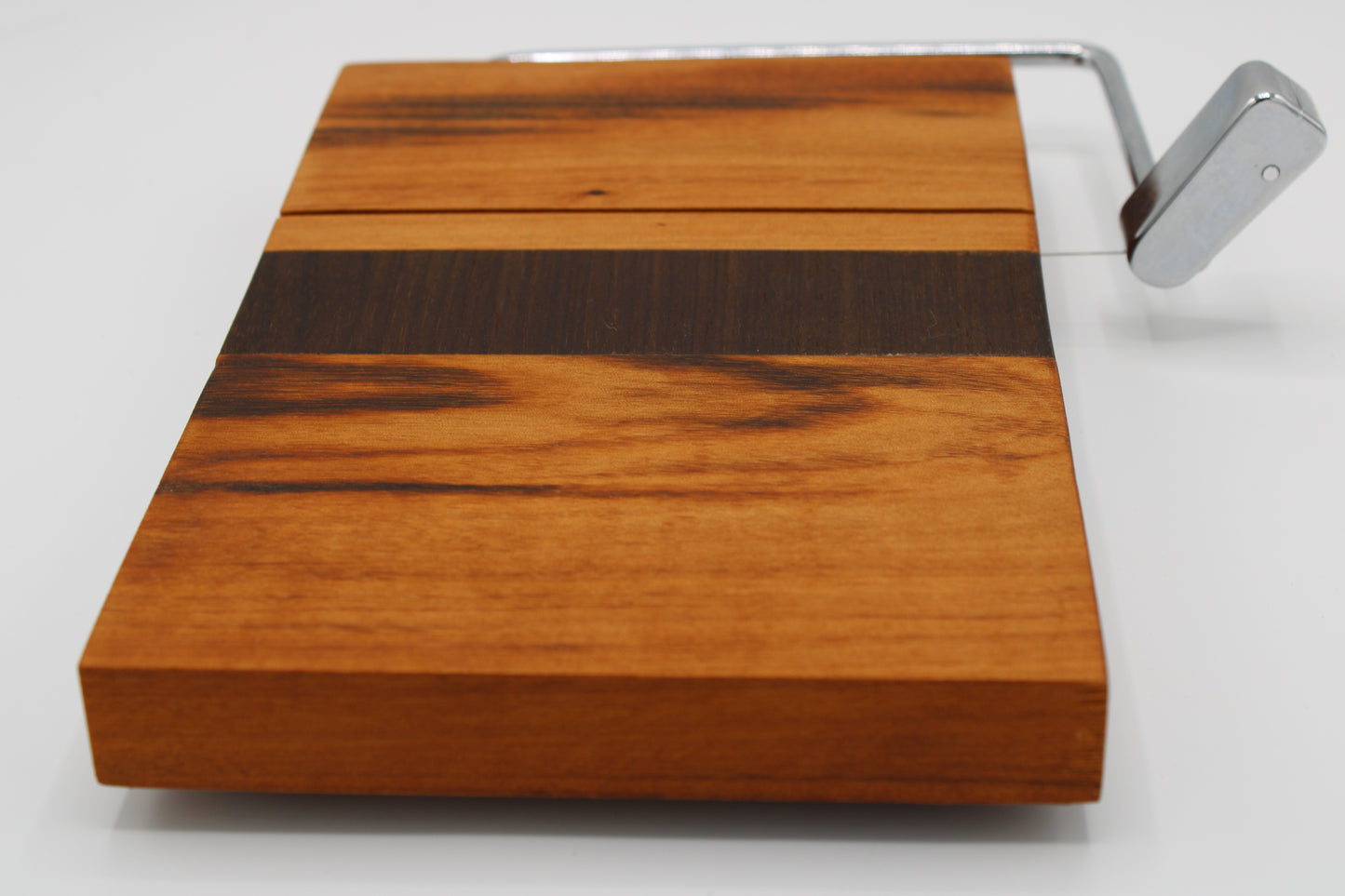 Wooden cheese board with slicer on a white background