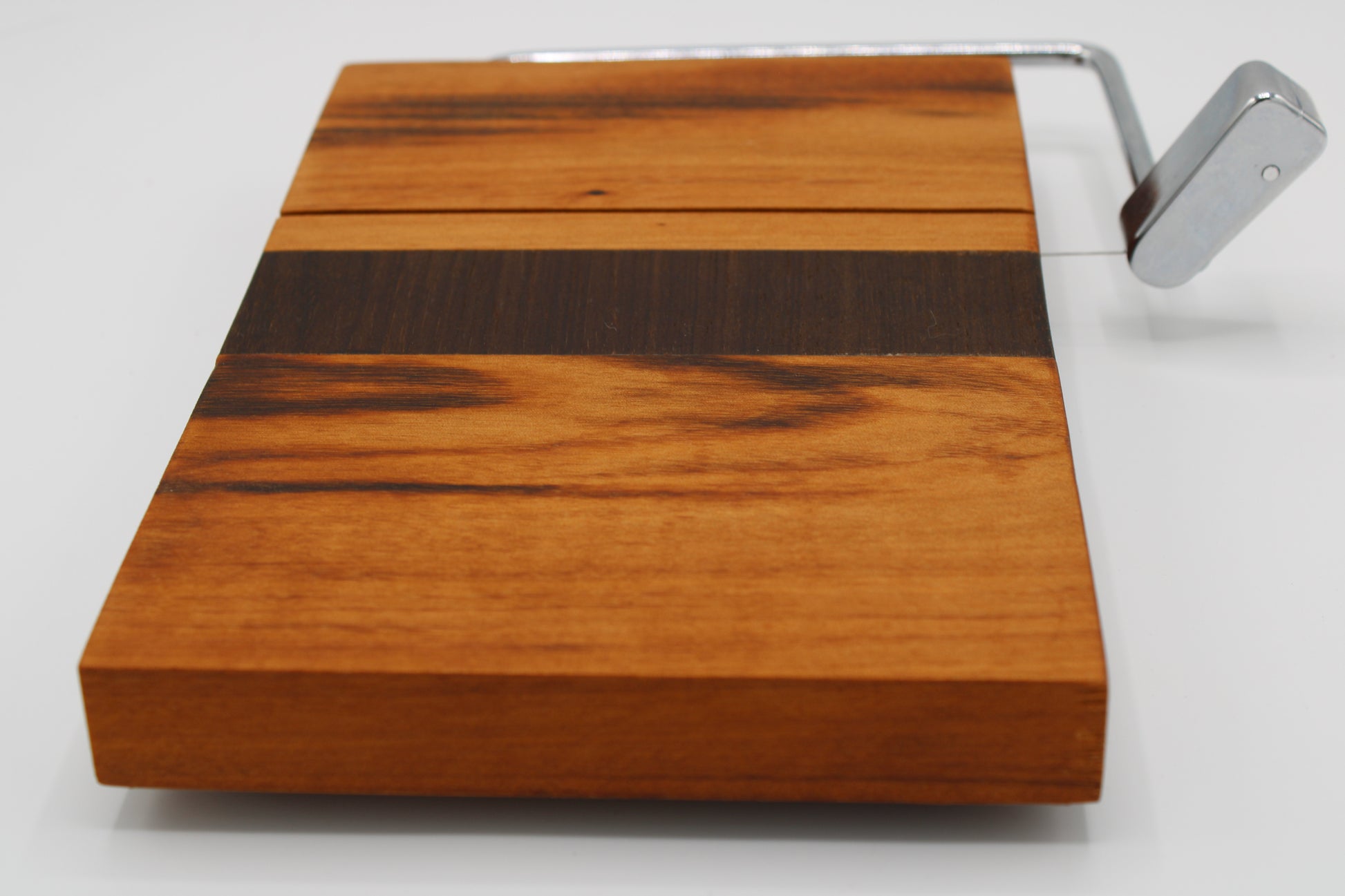 Wooden cheese board with slicer on a white background