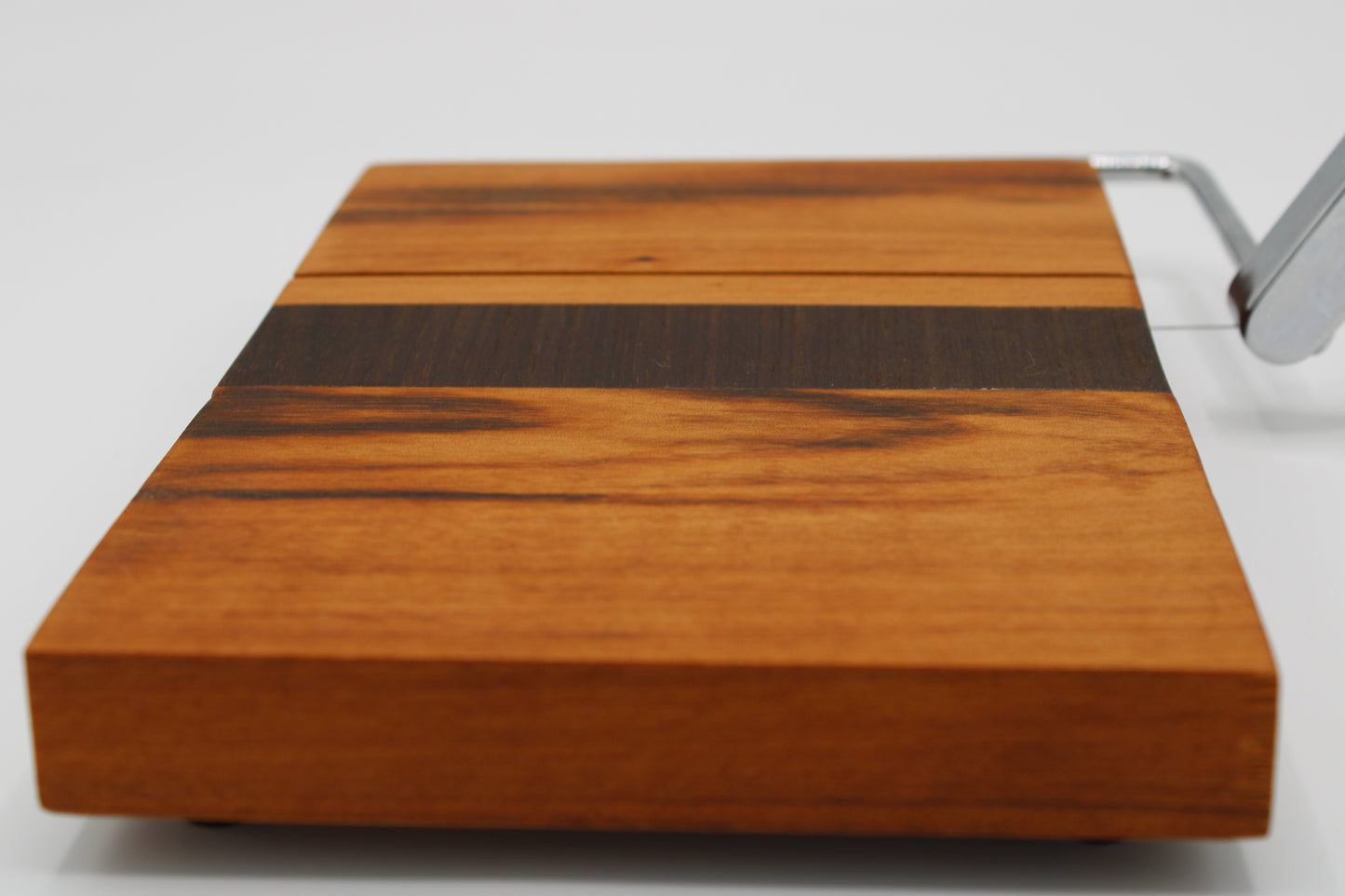 Wooden cheese board with slicer on a white background