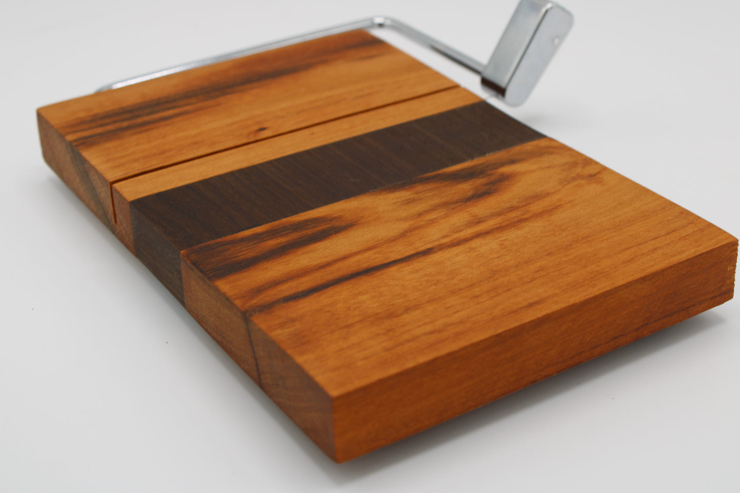 Wooden cheese board with slicer on a white background