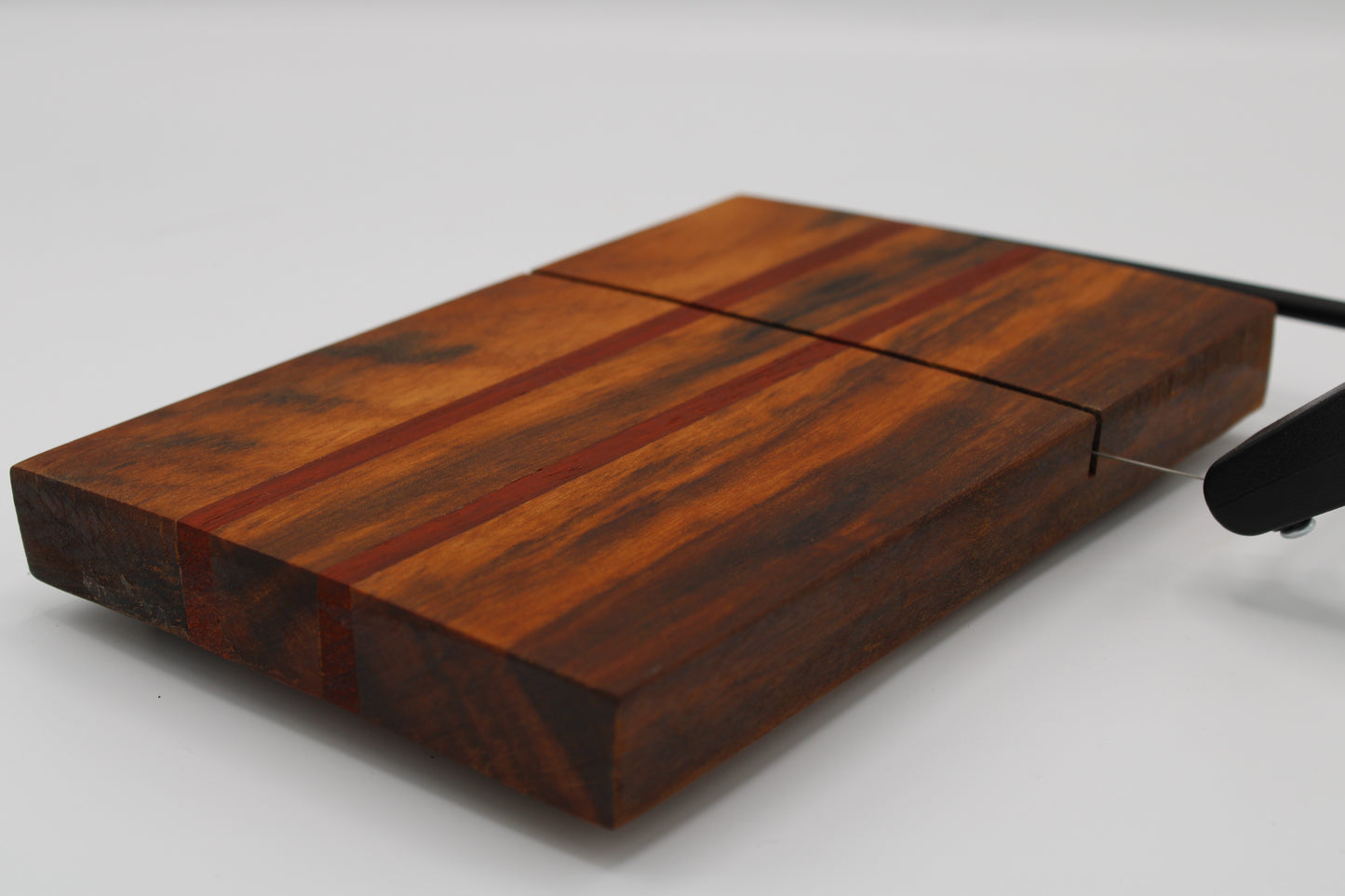 Wooden with cheese board with two red stripes on a white background