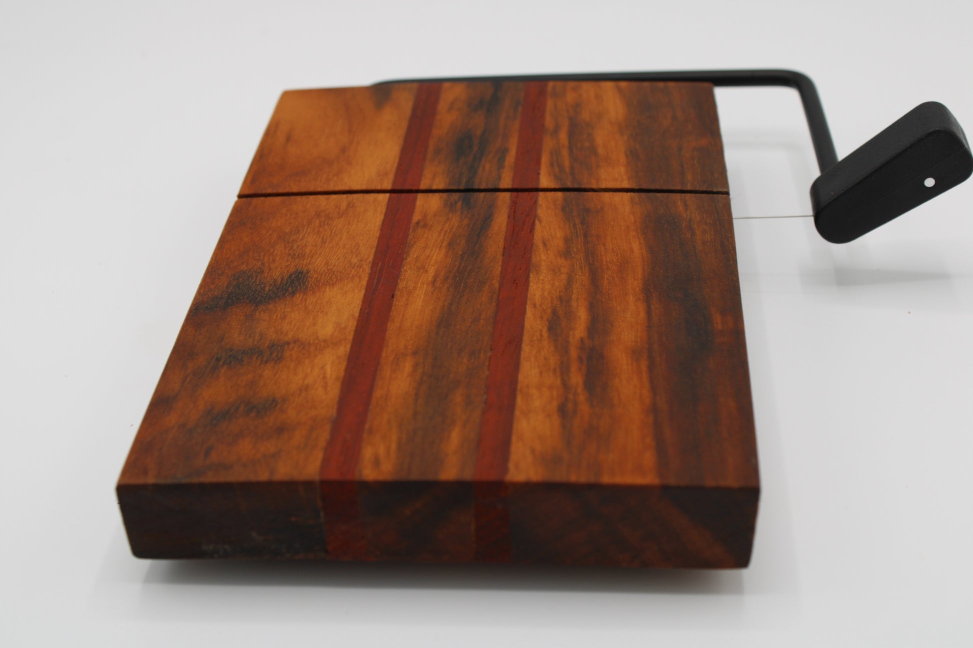 Wooden with cheese board with two red stripes on a white background