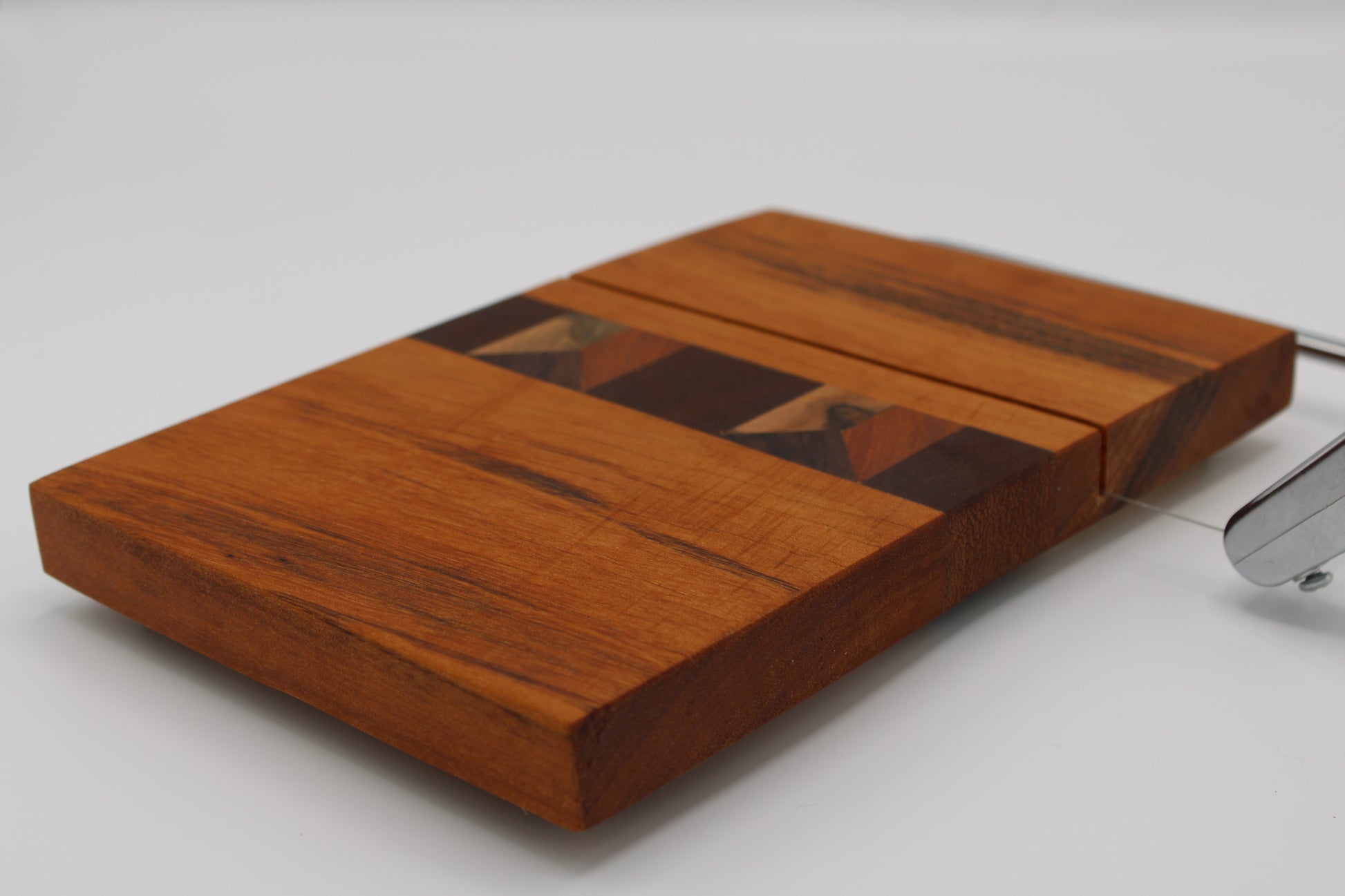 Wooden cheese board with slicer on a white background