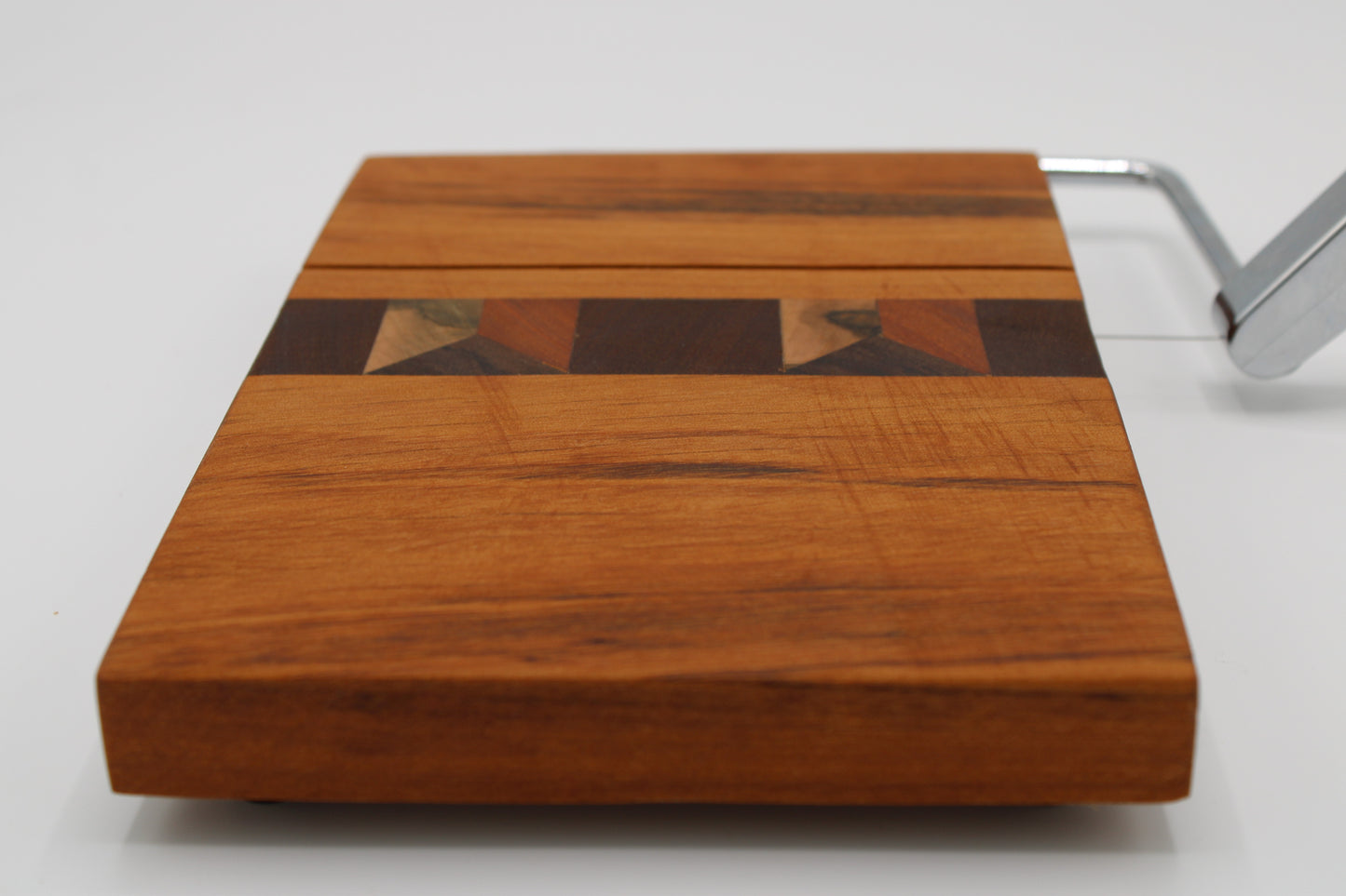 Wooden cheese board with slicer on a white background