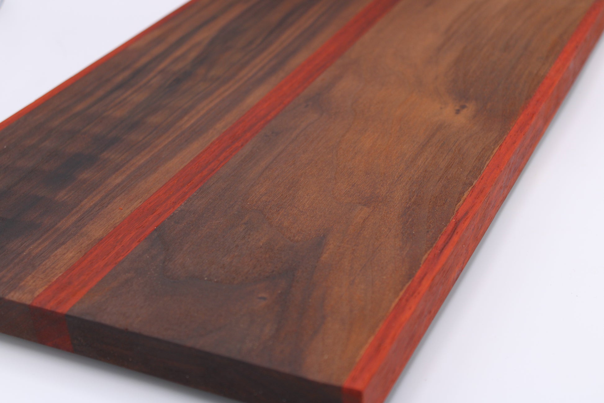 Wooden cutting board with a red stripe on a white background
