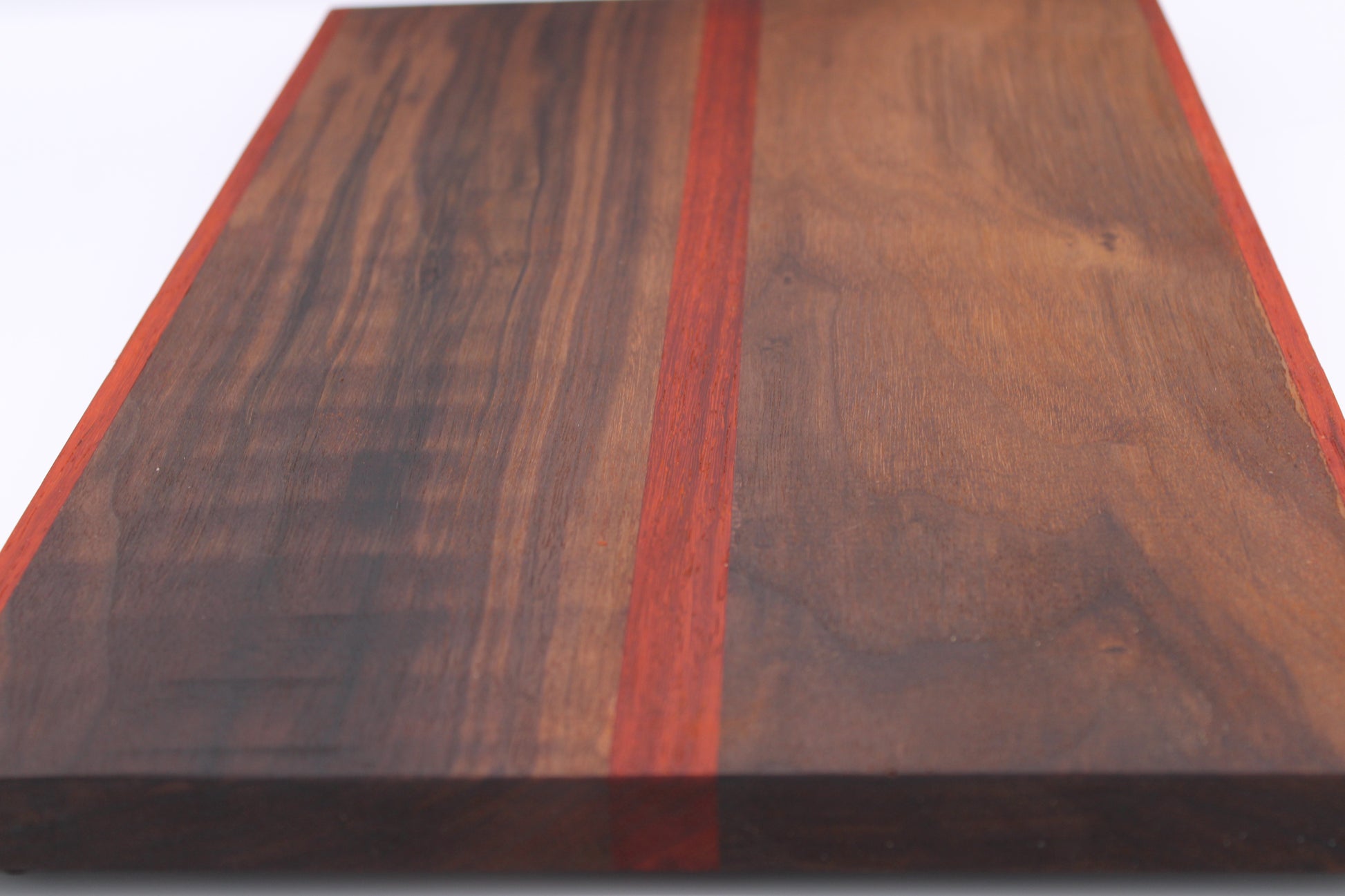 Wooden cutting board with a red stripe on a white background