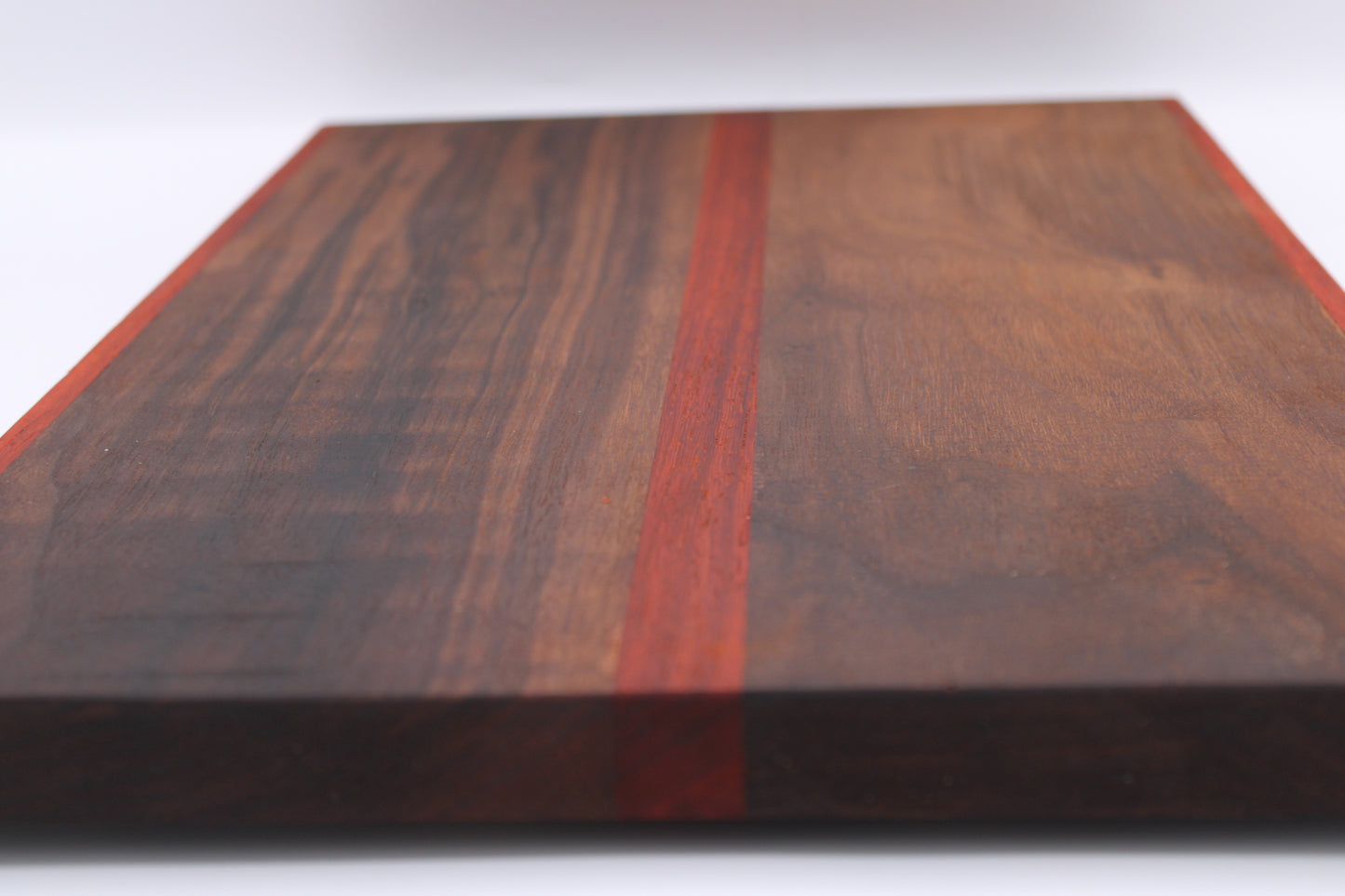 Wooden cutting board with a red stripe on a white background