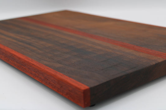 Wooden cutting board with a dark brown and red striped pattern on a white background