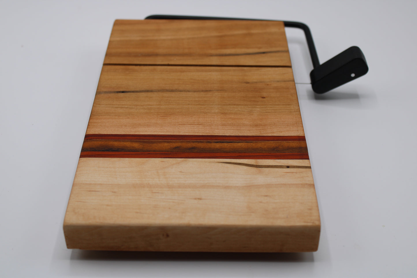 Wooden cheese cutting board with slicer on a white background