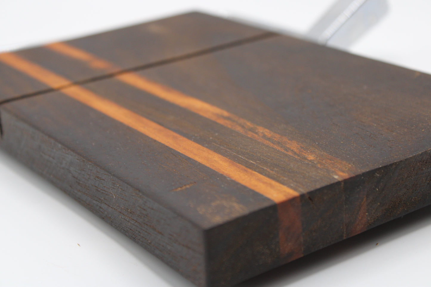 Wooden cheese cutting board with slicer on a light gray background