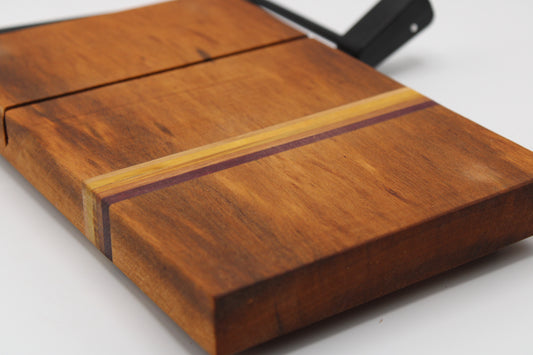 Wooden cheese cutting board with slicer on a light gray background