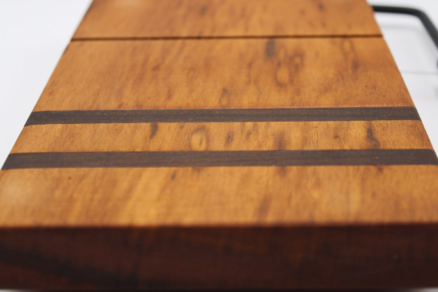 Wooden cheese cutting board with slicer on a light gray background