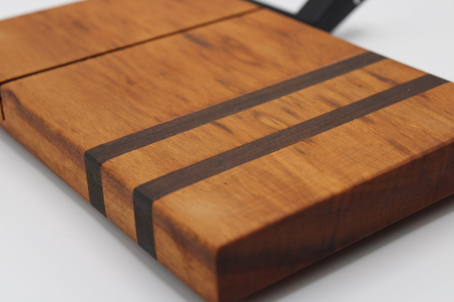 Wooden cheese cutting board with slicer on a light gray background