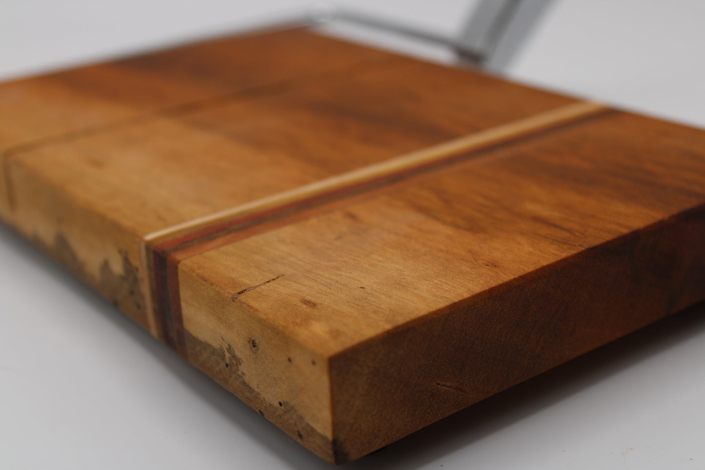 Wooden cheese cutting board with slicer on a light gray background