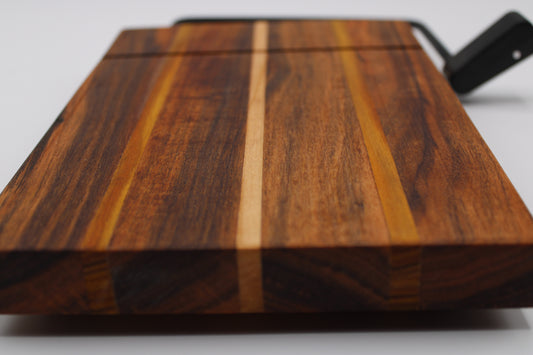 Wooden cheese cutting board with slicer on a light gray background