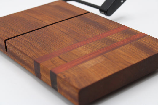 Wooden cheese cutting board with slicer on a light gray background