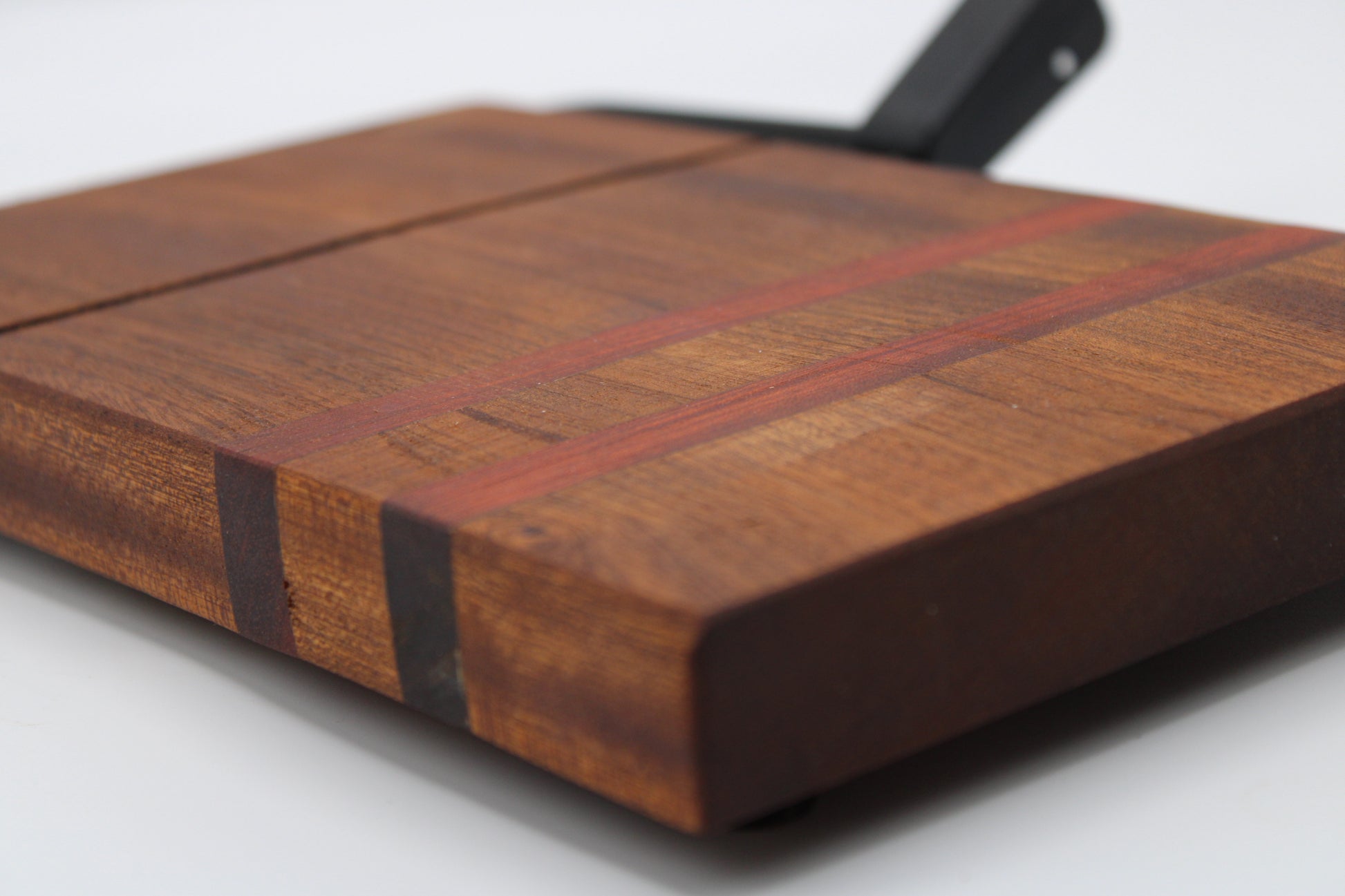 Wooden cheese cutting board with slicer on a light gray background