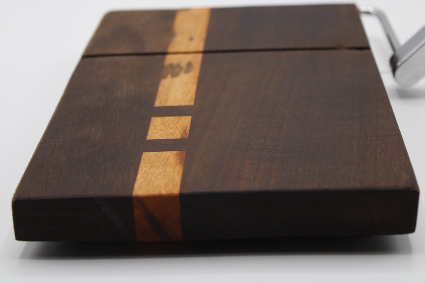 Wooden cheese cutting board with slicer on a light gray background