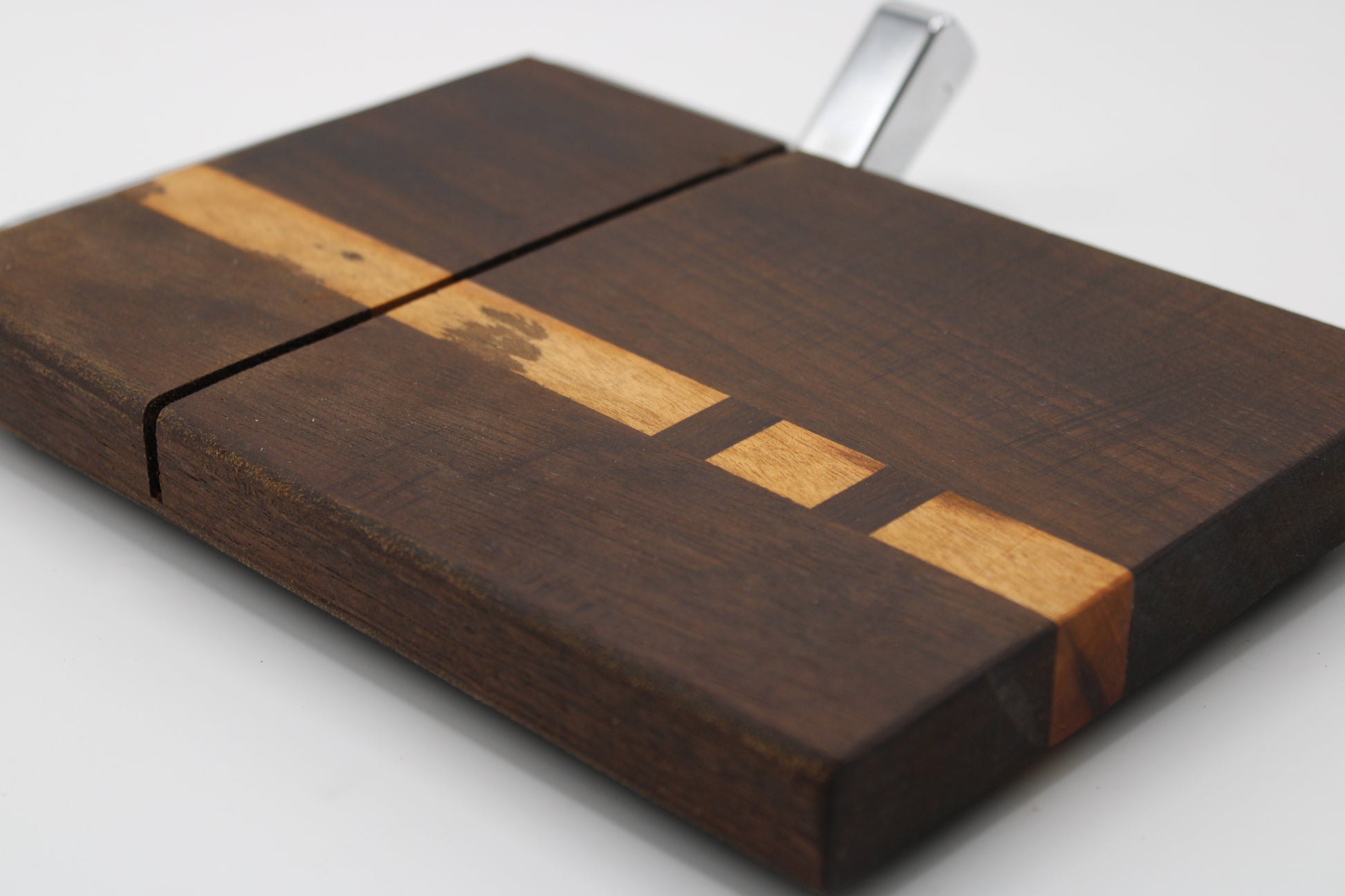 Wooden cheese cutting board with slicer on a light gray background