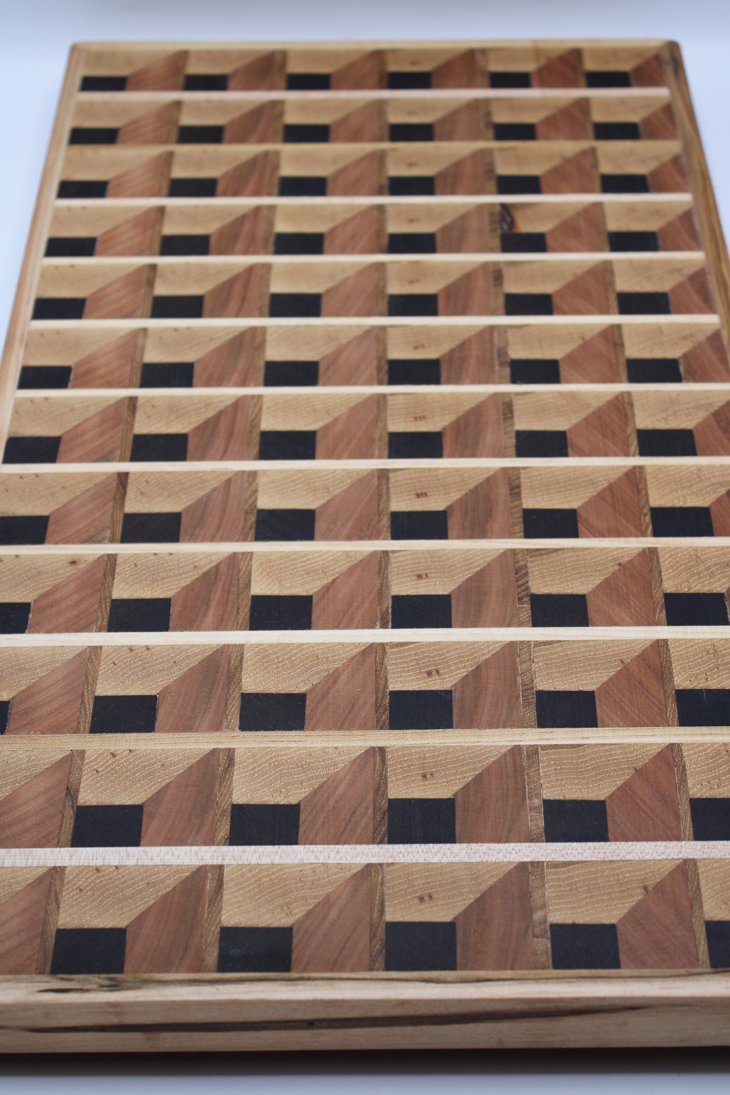 Wooden cutting board with a 3-D geometric pattern on a white background