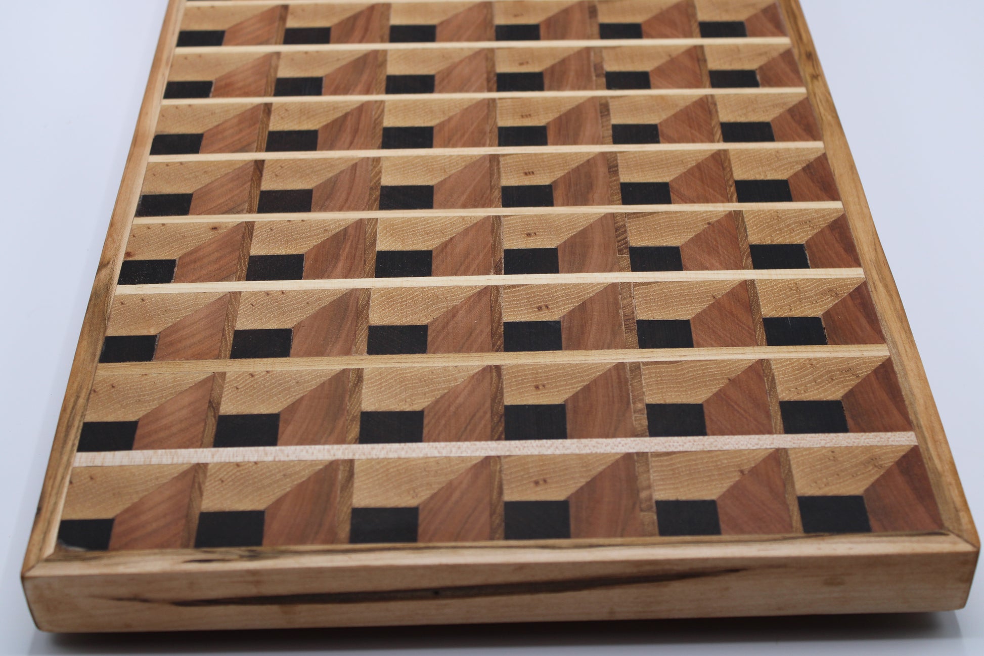 Wooden cutting board with a 3-D geometric pattern on a white background